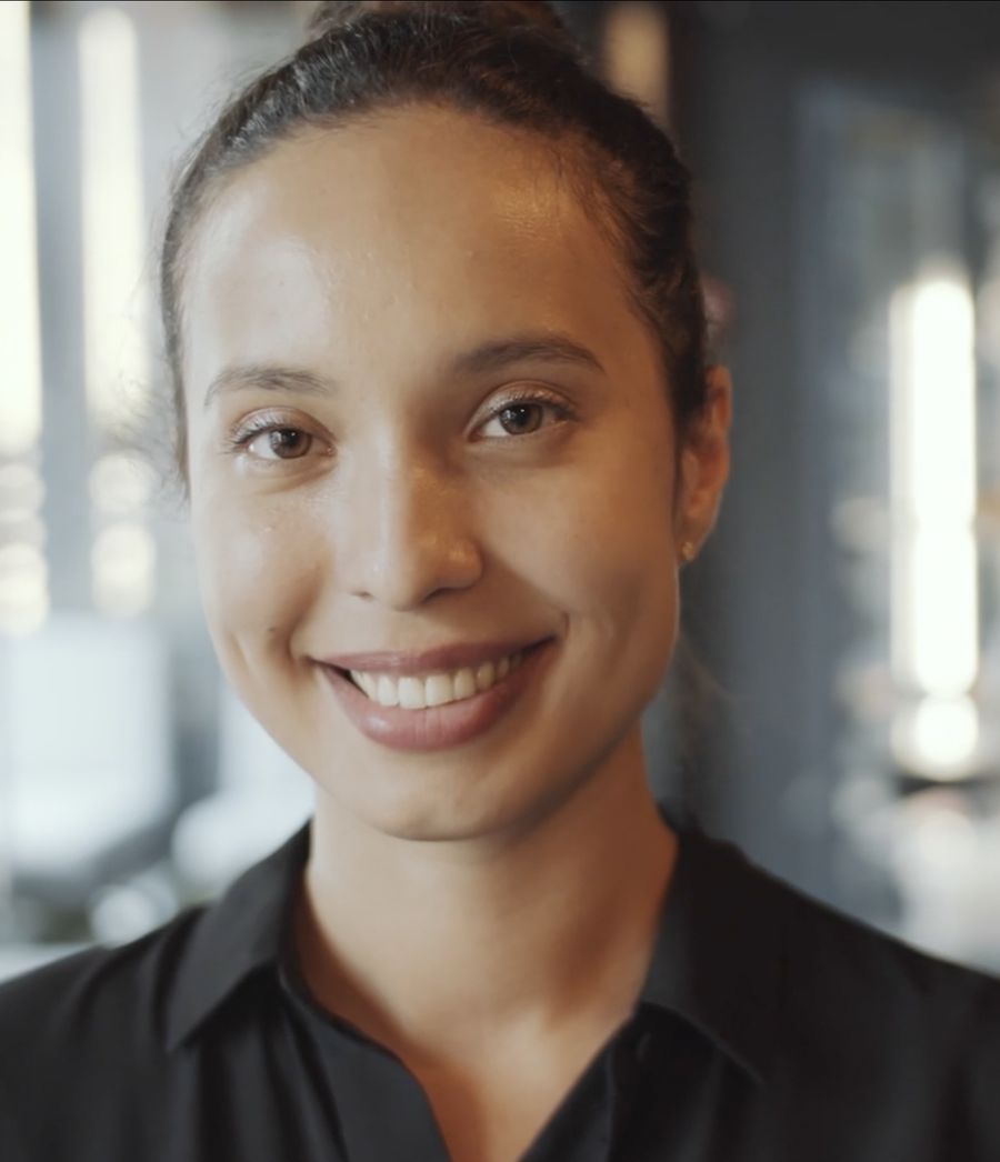 A smiling front-desk host in a hotel lobby